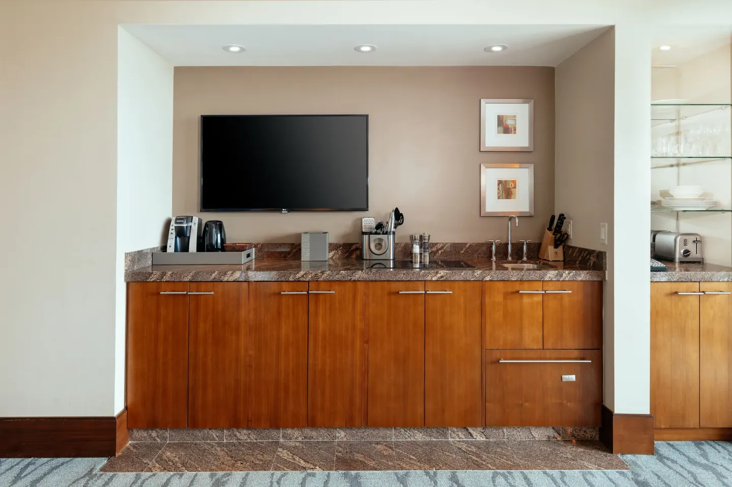 Studio Terrace View kitchenette with wood cabinets and TV at The Reef at Atlantis.