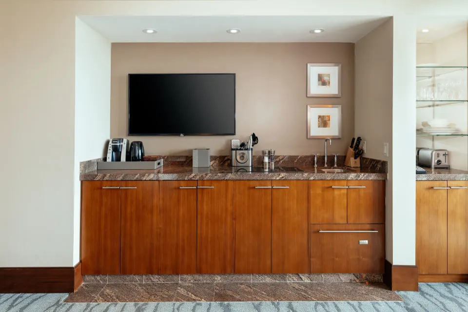 Studio Terrace View kitchenette with wood cabinets and TV at The Reef at Atlantis.