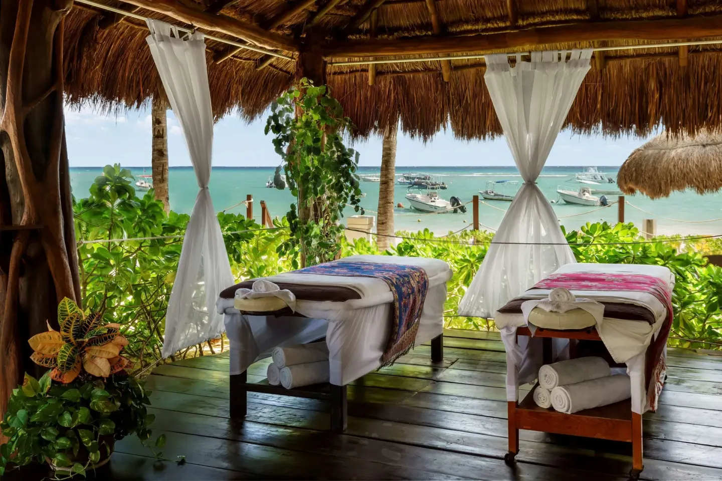 Beachfront spa palapa with two massage tables at The Reef Coco Beach Resort & Spa.