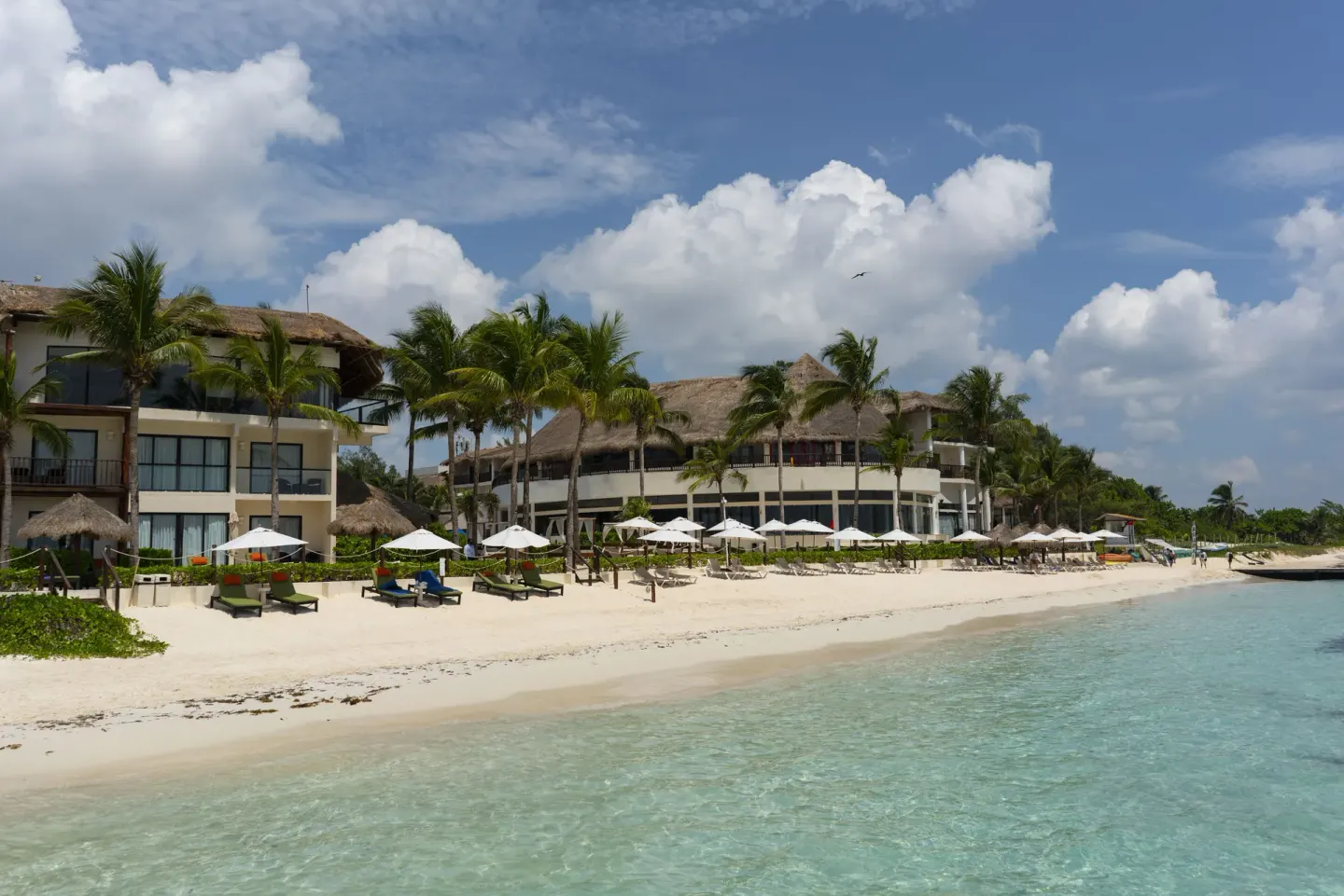 Beachfront resort buildings and umbrellas at The Reef Coco Beach Resort & Spa.