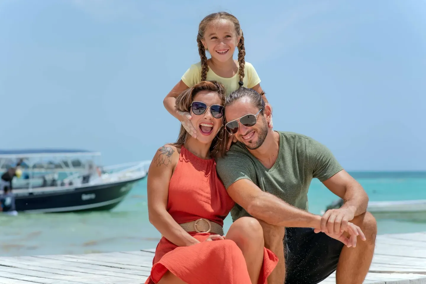 Family smiling on a beach pier at The Reef Coco Beach Resort & Spa.
