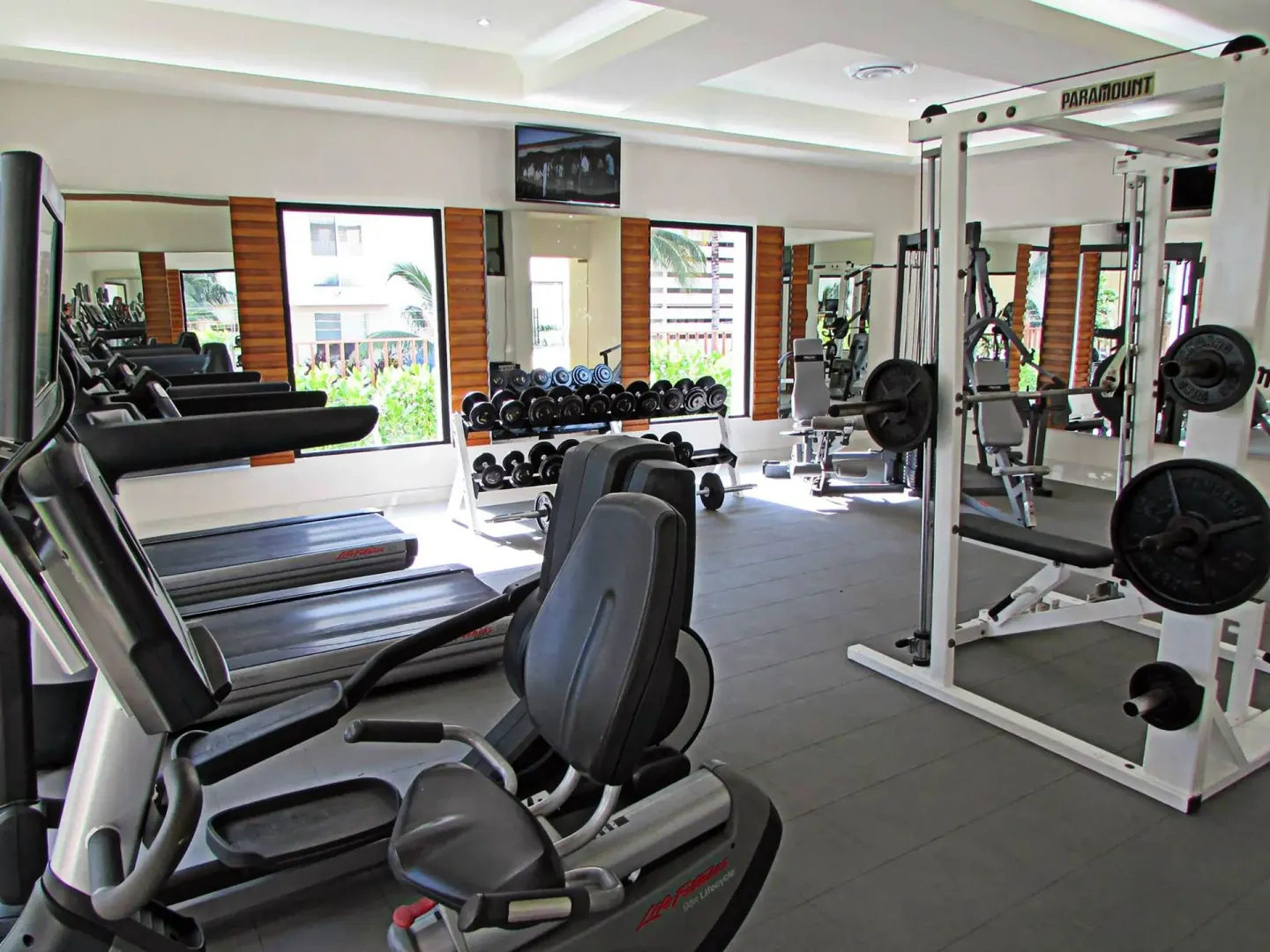 Resort fitness room with treadmills, dumbbells, and weight machines at The Reef Coco Beach Resort & Spa.