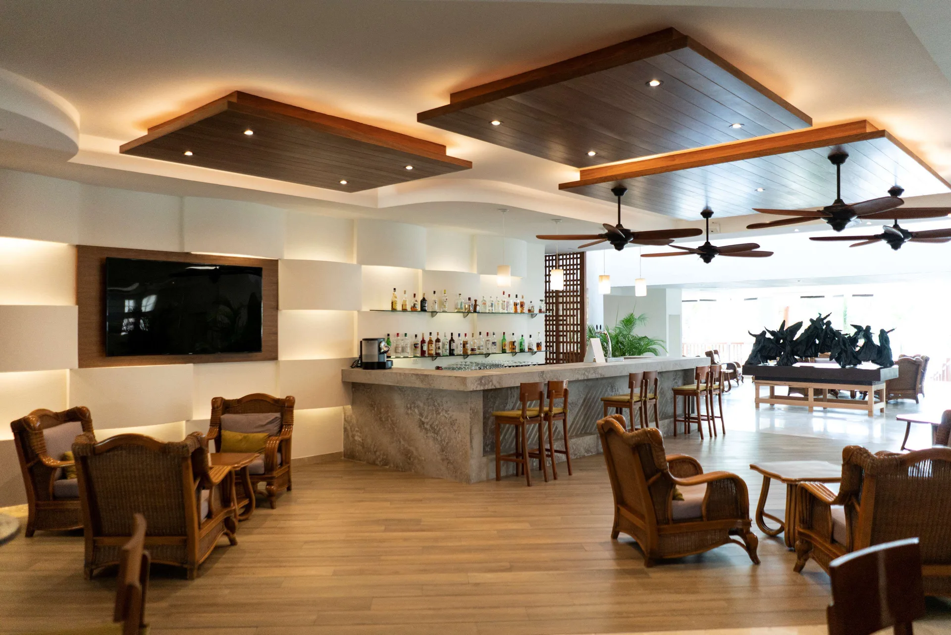 Lounge bar with marble counter and wicker seating at The Reef Coco Beach Resort & Spa.