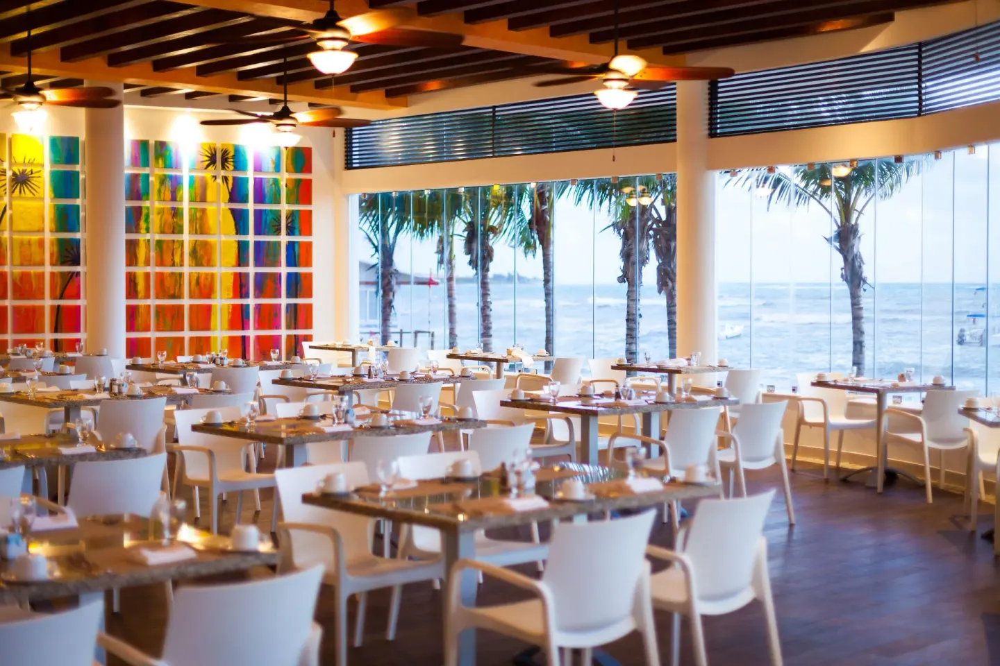 Large dining room with ocean-facing windows at The Reef Coco Beach Resort & Spa.