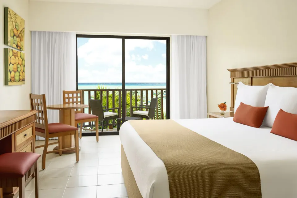 Premium Room with king bed and balcony ocean glimpse at The Reef Coco Beach Resort & Spa.