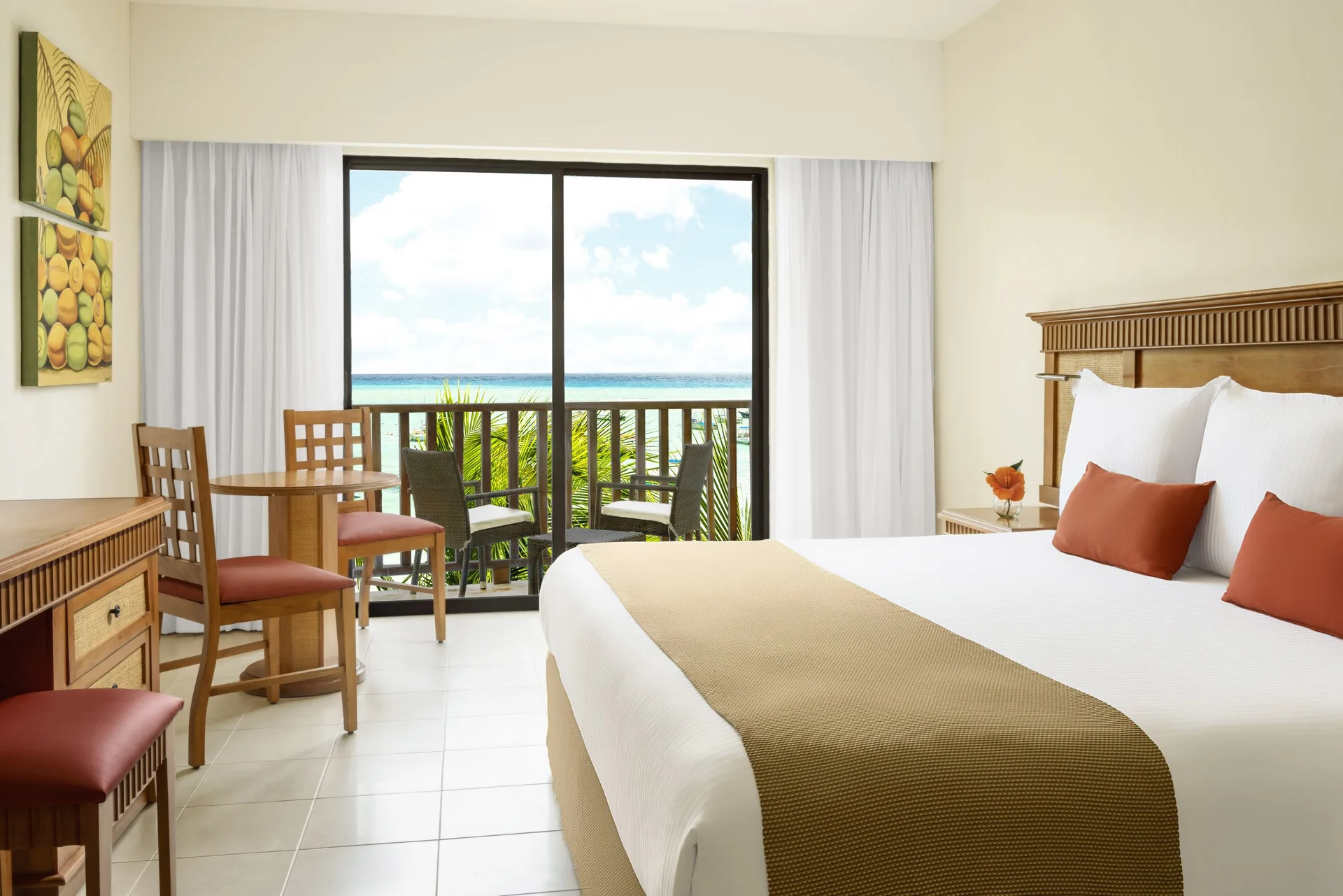 Premium Room with king bed and balcony ocean glimpse at The Reef Coco Beach Resort & Spa.