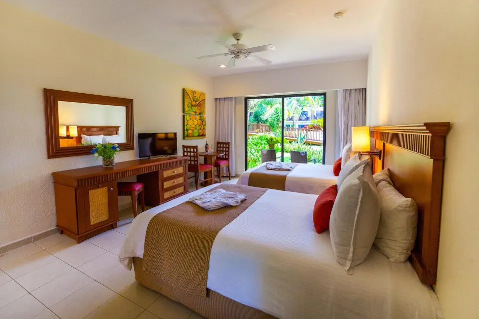 Superior Garden View Room with two beds and wood furnishings at The Reef Coco Beach Resort & Spa.