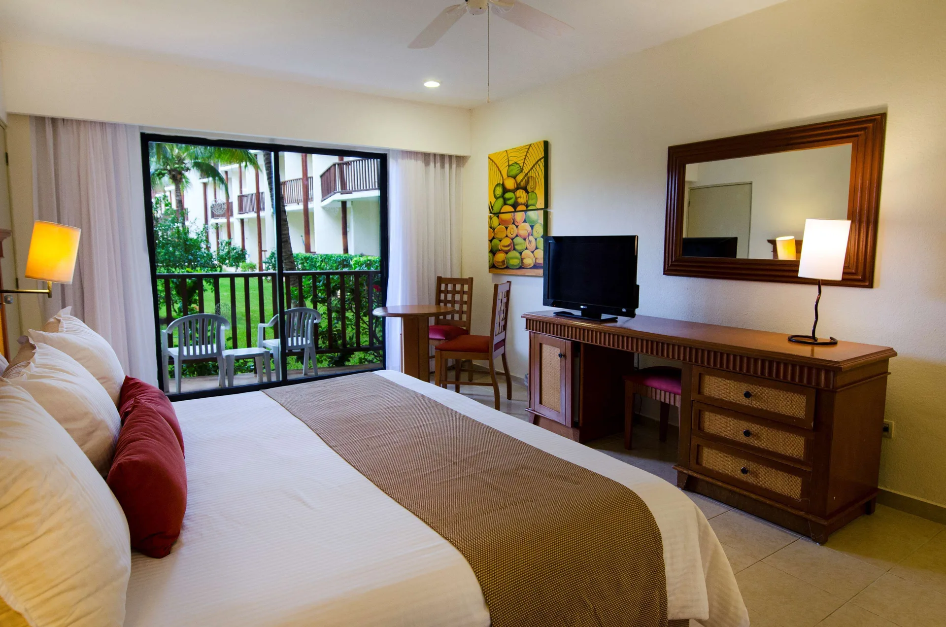 Superior Room Garden View with bed, desk, TV, and patio at The Reef Coco Beach Resort & Spa.