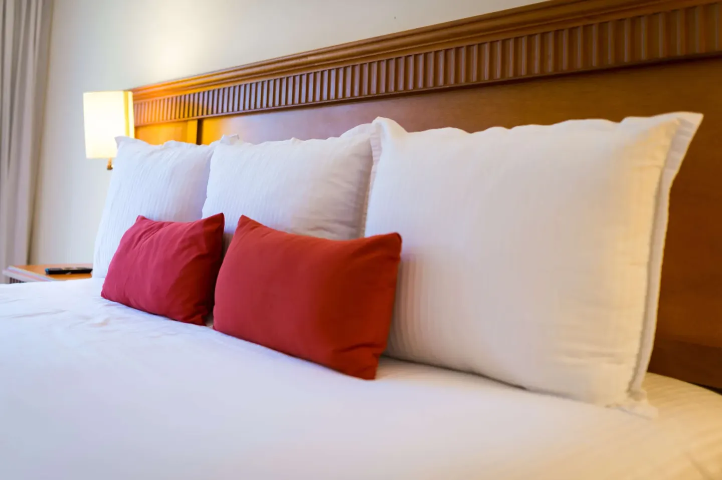 Superior Room Garden View bed pillows and wood headboard at The Reef Coco Beach Resort & Spa.