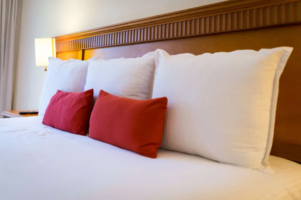 Superior Room Garden View bed pillows and wood headboard at The Reef Coco Beach Resort & Spa.