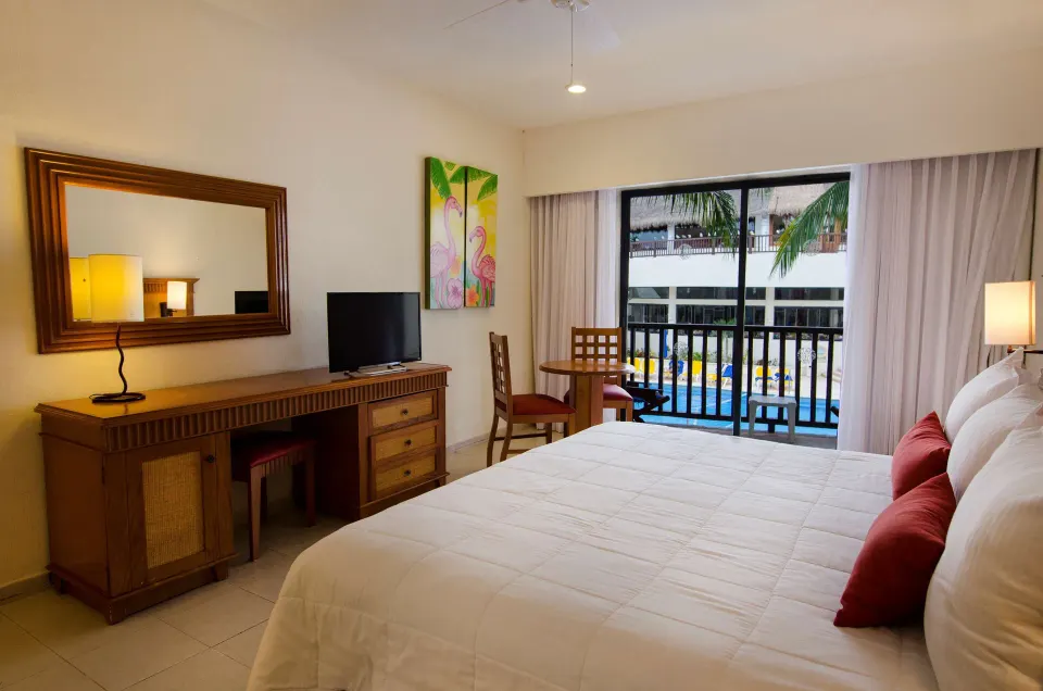 Superior Room Pool View with king bed and balcony at The Reef Coco Beach Resort & Spa.