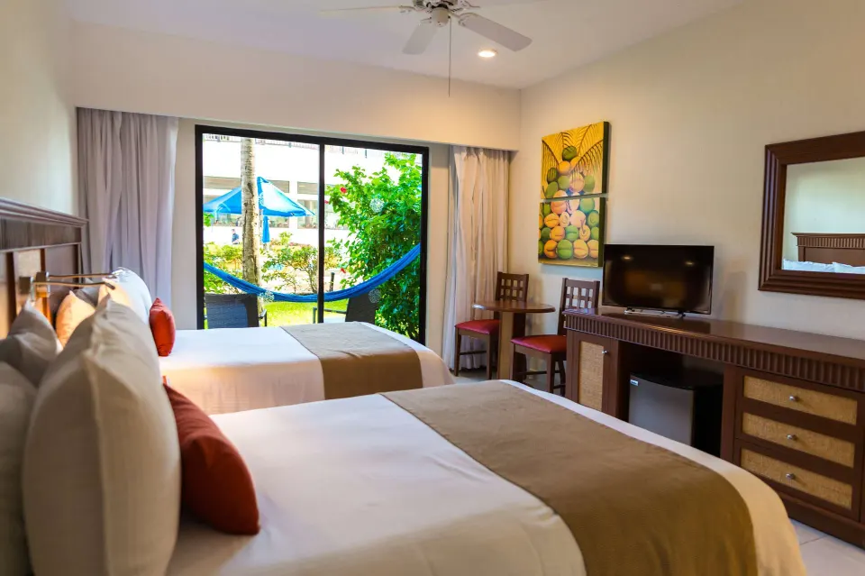 Superior Room Pool View with two beds and patio hammock at The Reef Coco Beach Resort & Spa.