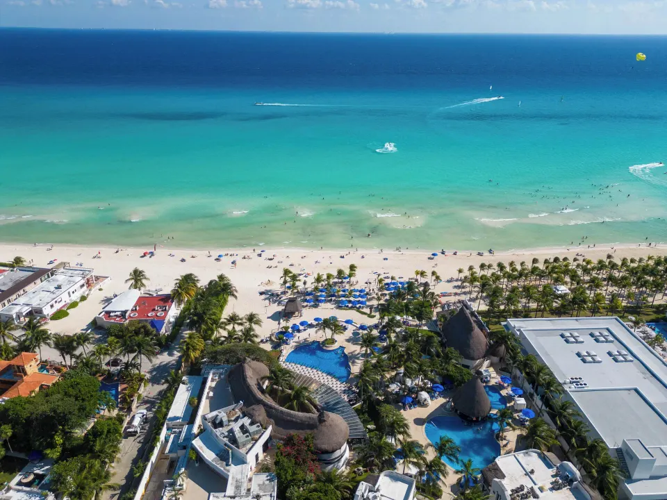 Aerial view of The Reef Playacar Beach Resort & Spa with pools and the Caribbean beach