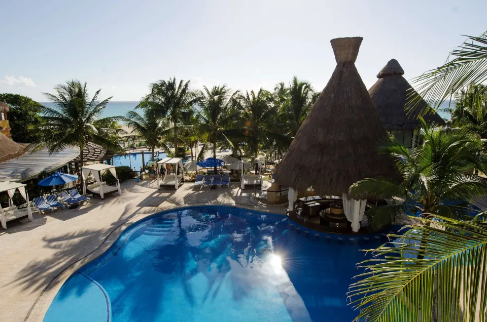 Aerial view of the resort pool, palapa bar and beach at The Reef Playacar Beach Resort & Spa