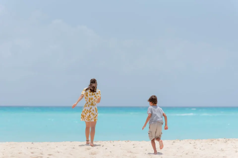 Two children standing at the water's edge on The Reef Playacar Beach Resort & Spa beach