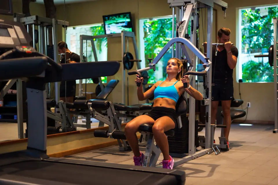 Guests working out in the resort fitness center at The Reef Playacar Beach Resort & Spa