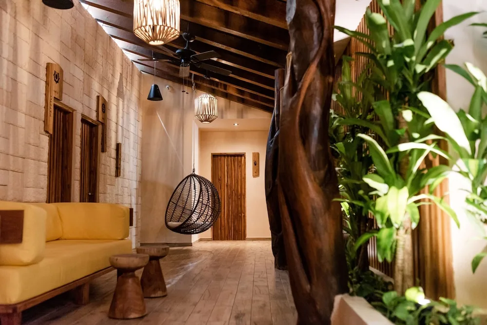 Cozy lobby corridor with swing chair and seating at The Reef Playacar Beach Resort & Spa