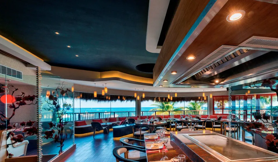 Ocean-view restaurant interior with teppanyaki-style grill at The Reef Playacar Beach Resort & Spa