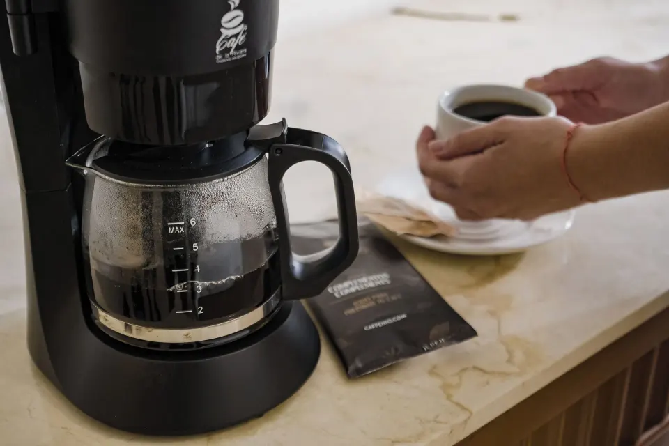 Drip coffee maker and cup on a counter in a room at The Reef Playacar Beach Resort & Spa