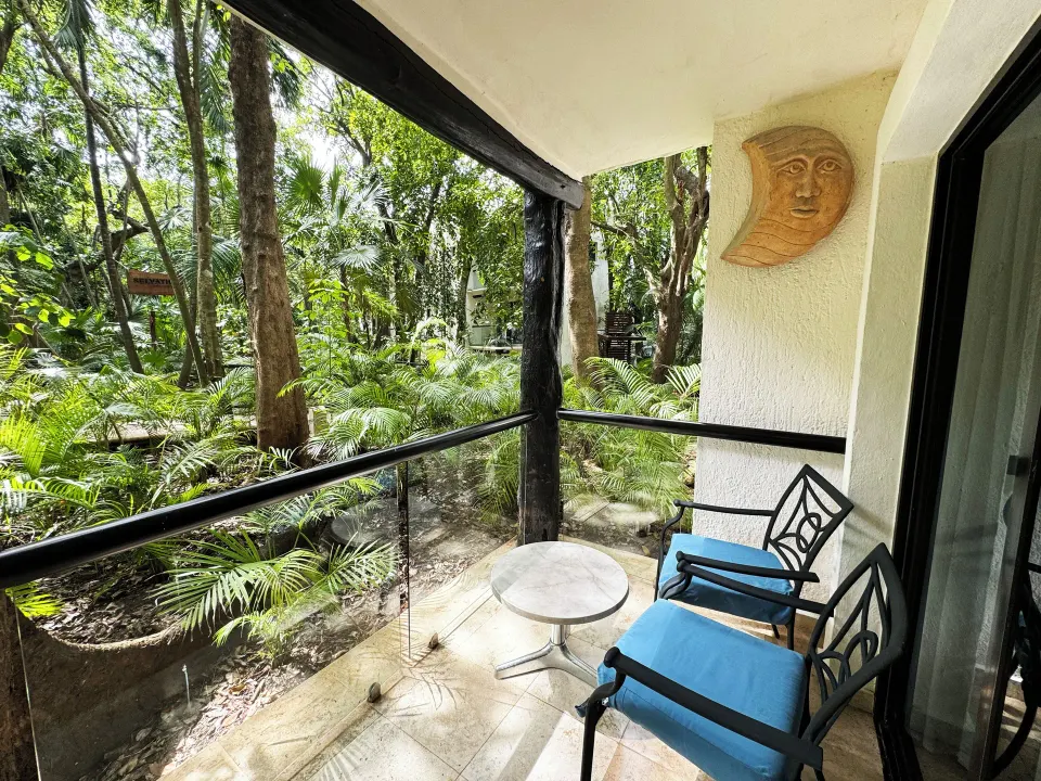 Private balcony with chairs overlooking lush tropical gardens at The Reef Playacar Beach Resort & Spa