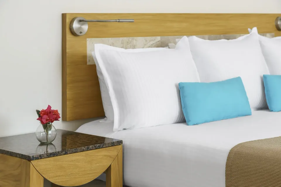 Another close-up of headboard and bedside table with reading light in a Superior Room at The Reef Playacar Beach Resort & Spa