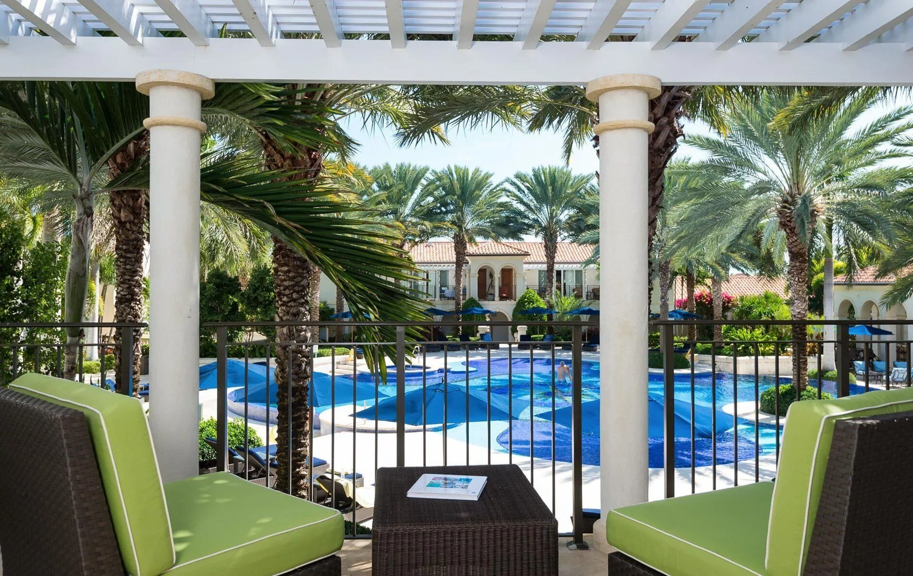 Balcony seating overlooks the pool and palms at The Regent Grand.