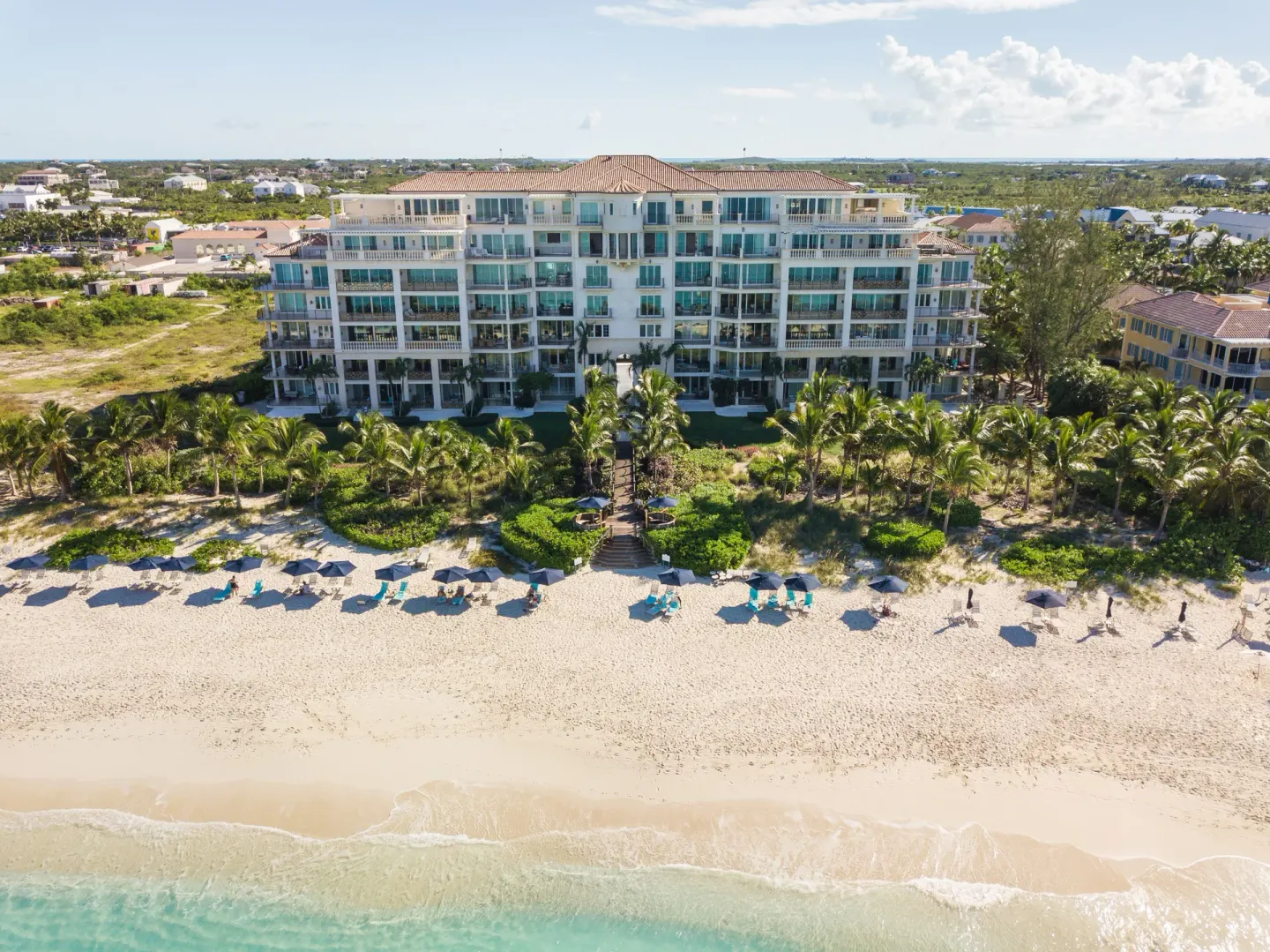 Beachfront aerial view of The Regent Grand with loungers on the sand.
