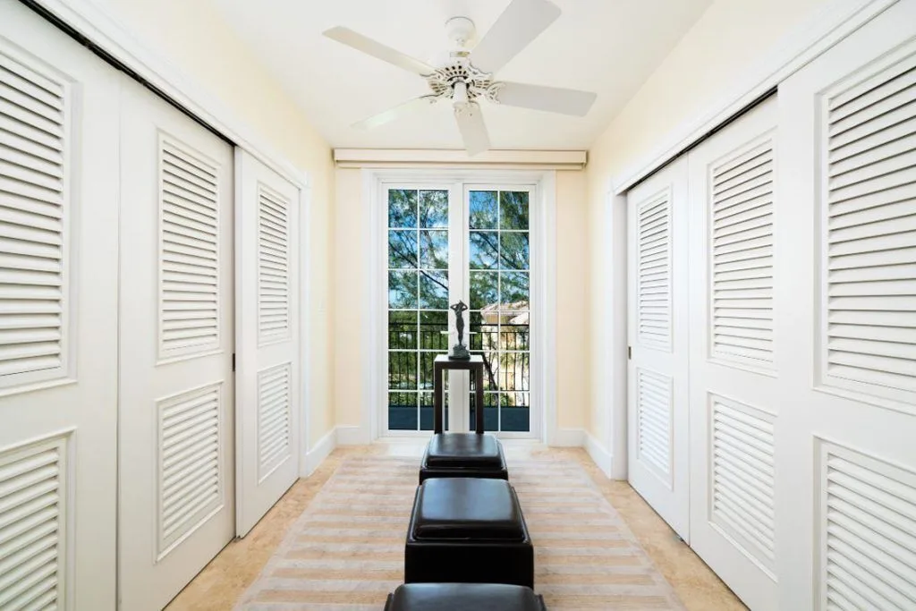 Dressing area with louvered closet doors, benches and glass balcony doors at The Regent Grand.