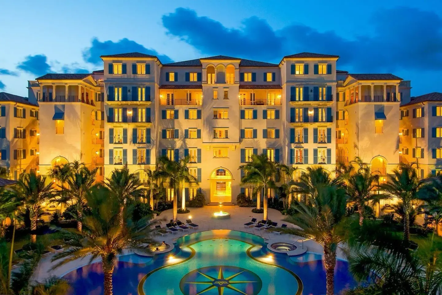 Illuminated resort building and pool at dusk at The Regent Grand.