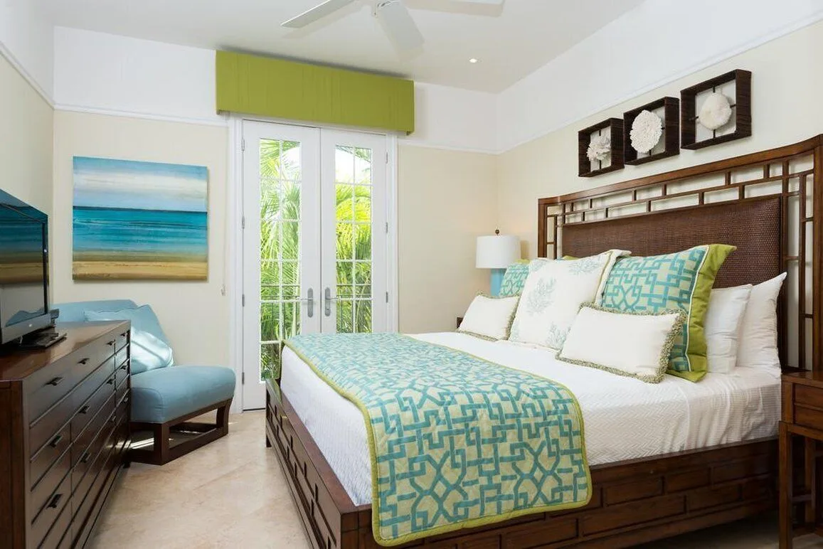 Guest room with king bed, turquoise accents, and French doors at The Regent Grand.