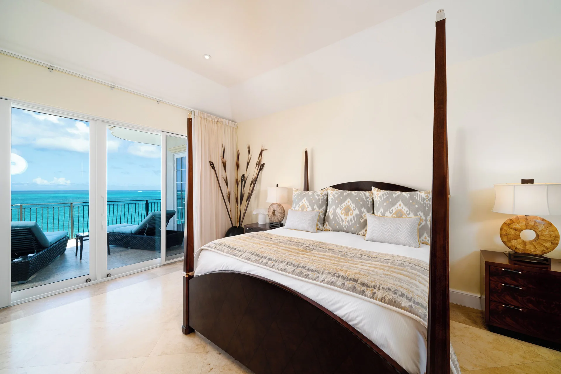 Ocean-view guest room with four-poster king bed at The Regent Grand.