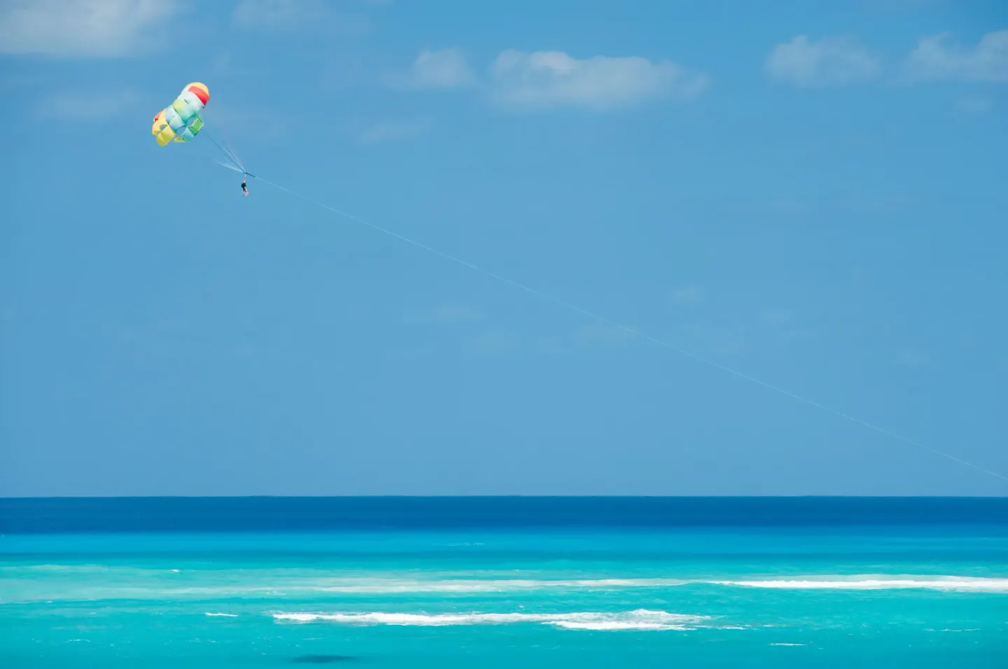 Parasail above turquoise ocean water near The Regent Grand.
