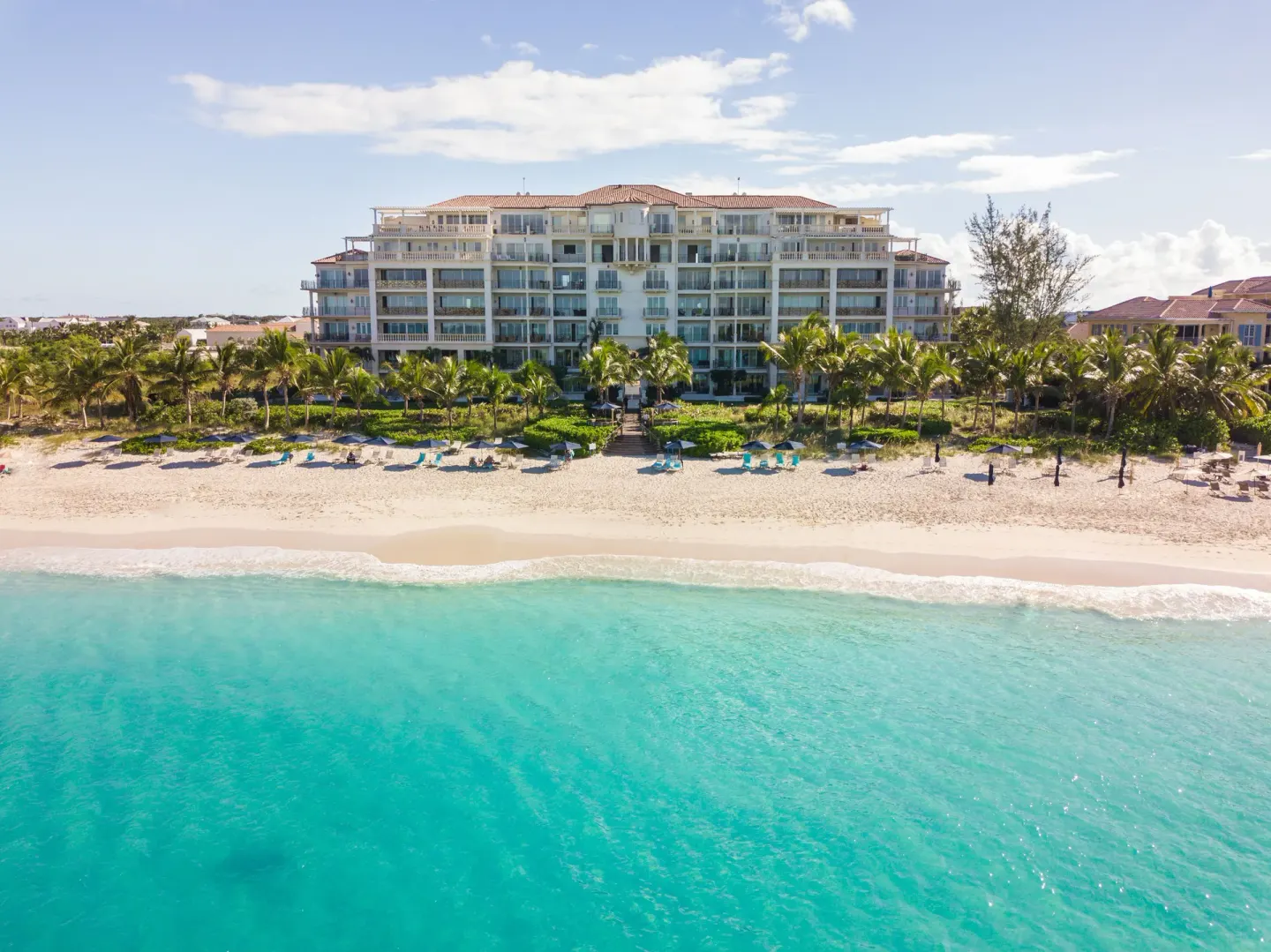 Wide oceanfront view of The Regent Grand across turquoise water.