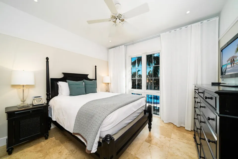 Oceanfront one-bedroom suite with a four-poster bed and palm views at The Regent Grand.