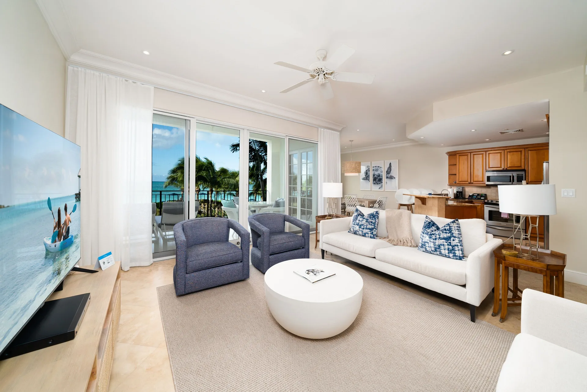 Oceanfront one-bedroom suite living room with balcony doors and sea view at The Regent Grand.
