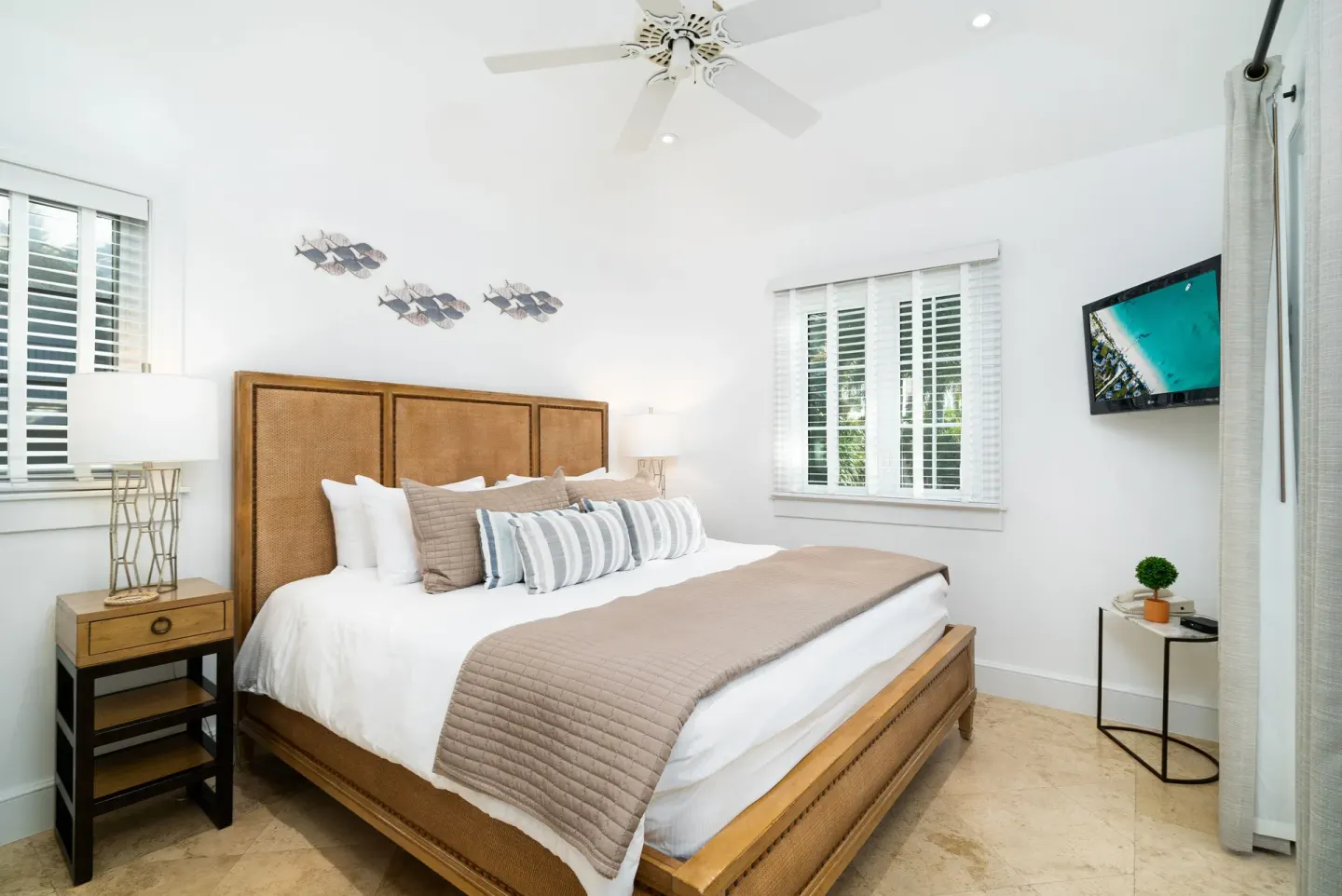 One-bedroom pool view suite bedroom with king bed and wall-mounted TV at The Regent Grand.