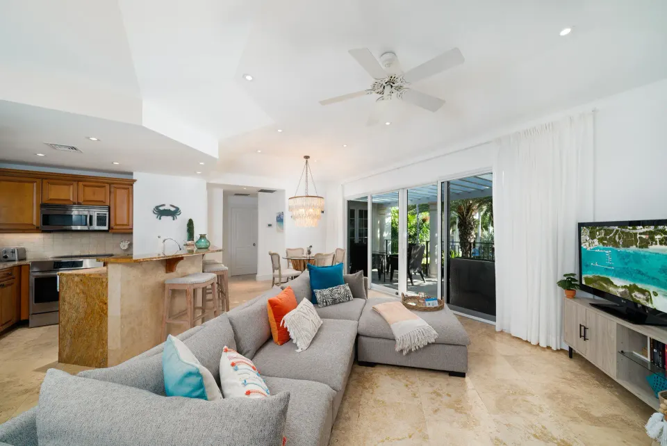One-bedroom pool view suite living area with sofa, kitchen, dining area, and balcony at The Regent Grand.