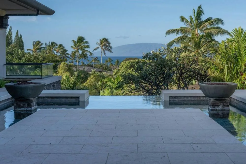 Infinity water feature opening to tropical landscaping and ocean view at The Resort at Kapalua Bay, Maui