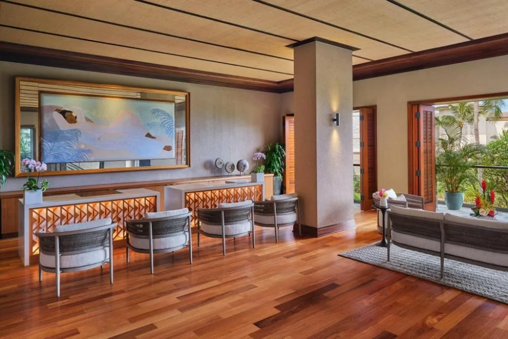 Open lobby lounge with seating, wooden floors and ocean view at The Resort at Kapalua Bay, Maui