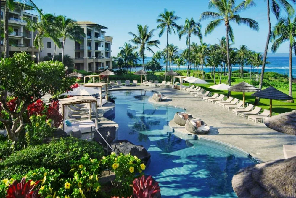 Resort pool with cabanas and ocean beyond at The Resort at Kapalua Bay, Maui