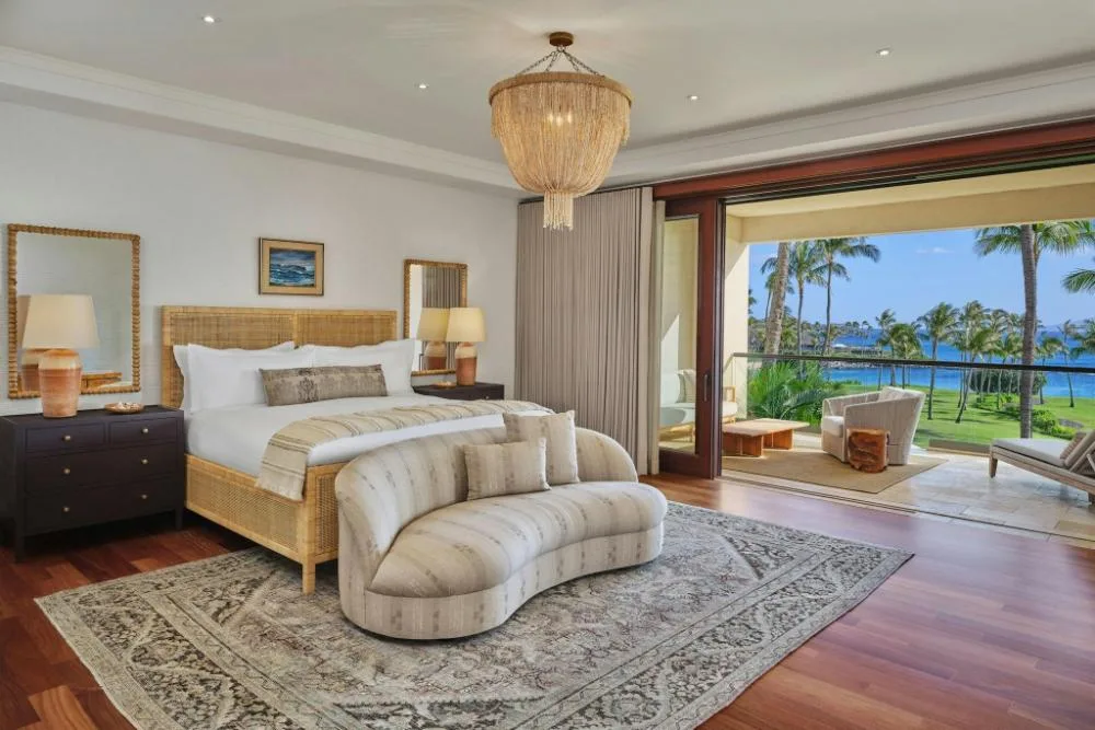 Spacious suite bedroom with king bed and balcony overlooking the lawn at The Resort at Kapalua Bay, Maui