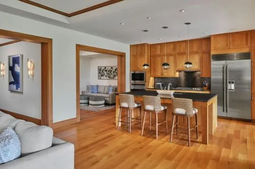 Suite kitchen and open-plan living area with island seating at The Resort at Kapalua Bay, Maui