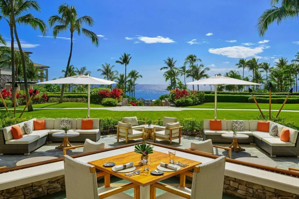 Outdoor lounge seating and ocean view across the resort lawns at The Resort at Kapalua Bay, Maui