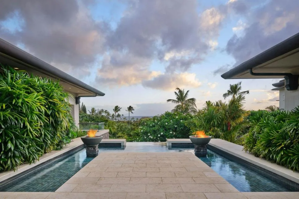 Reflecting pool terrace with fire bowls and distant ocean at The Resort at Kapalua Bay, Maui