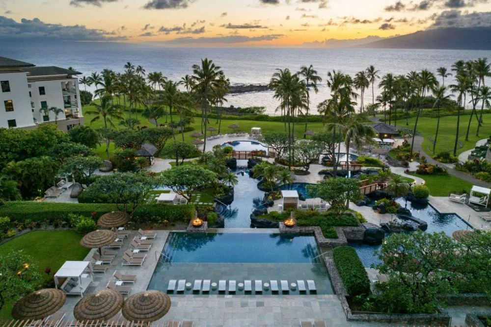 Resort pool and lawn with ocean sunset view at The Resort at Kapalua Bay, Maui