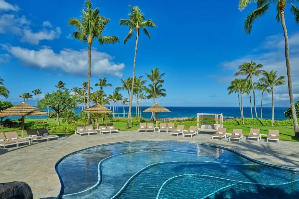 Resort swimming pool with lounge chairs and ocean view at The Resort at Kapalua Bay, Maui