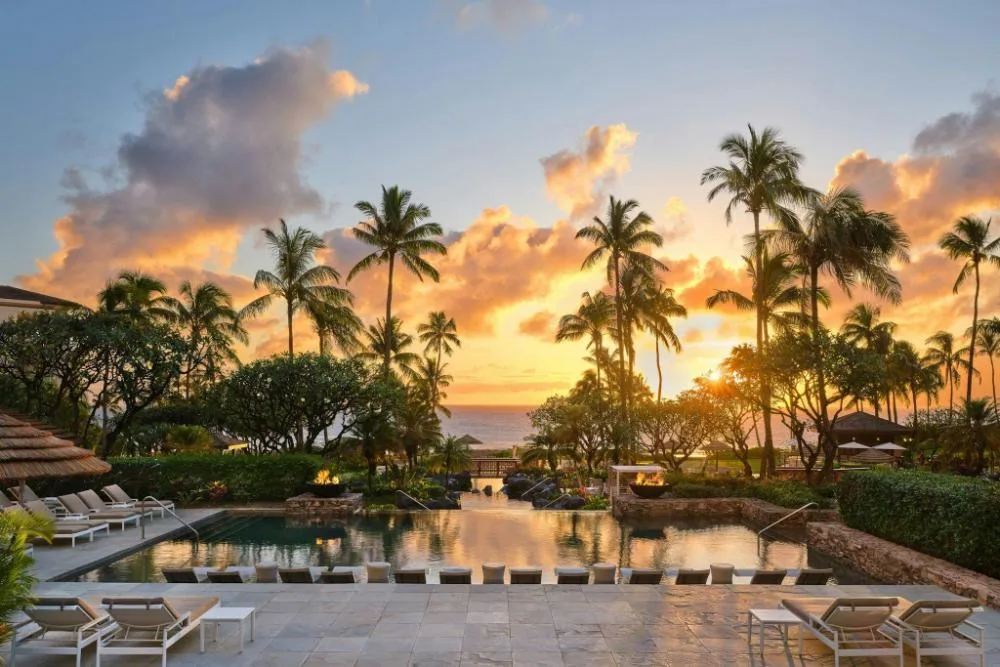 Sunset over the resort pool with silhouetted palms at The Resort at Kapalua Bay, Maui