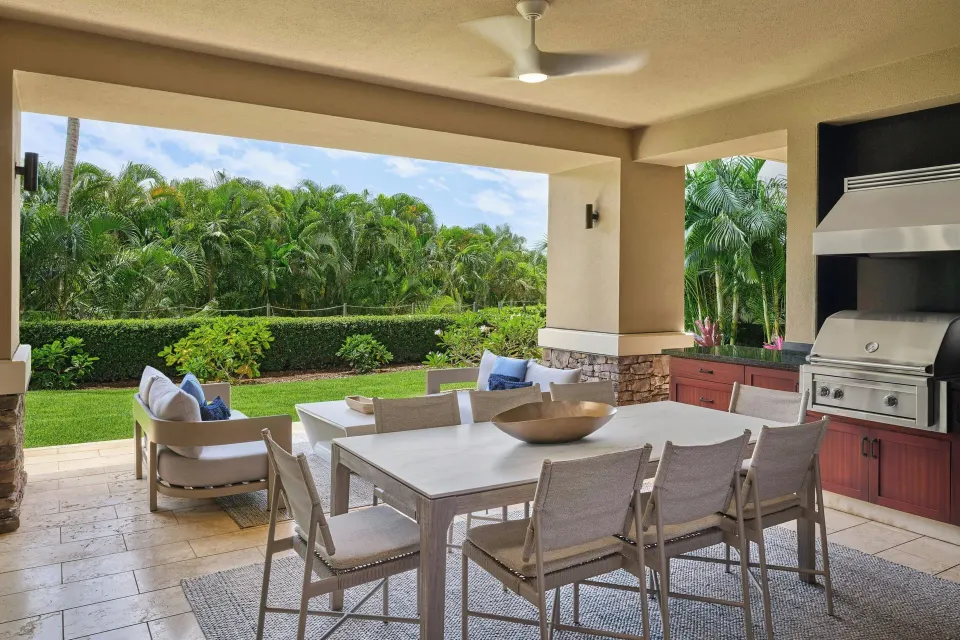 Covered lanai dining area with grill and garden view in a 3 Bedroom Residence at The Resort at Kapalua Bay, Maui