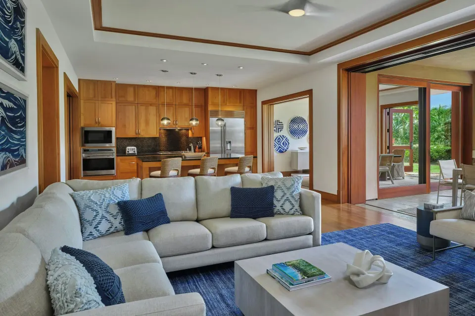 Living room with sectional sofa and open kitchen in a 3 Bedroom Residence at The Resort at Kapalua Bay, Maui