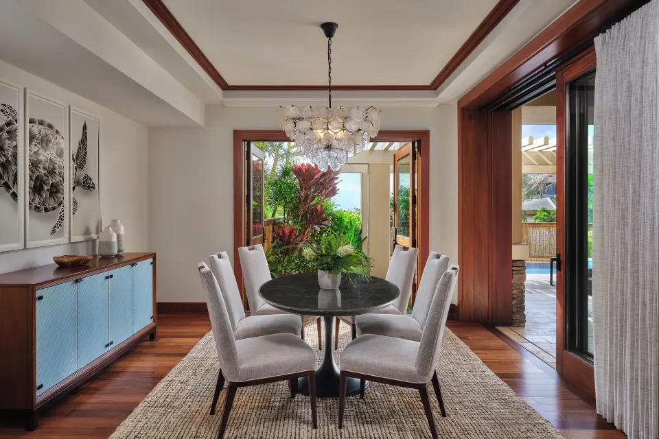 Dining area with round table opening to a lanai in a 3 Bedroom Residence at The Resort at Kapalua Bay, Maui